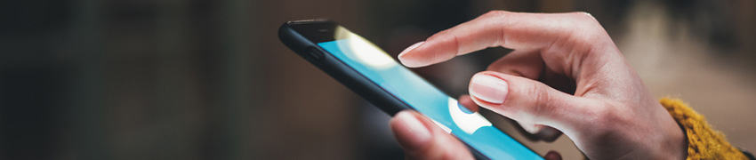 A woman using her phone to check her finances at night.