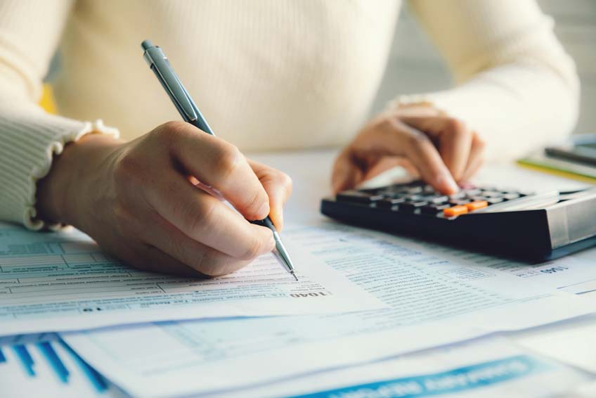 A woman filing her taxes at a desk.