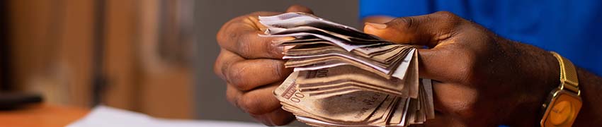 A man flipping through a stack of dollar bills