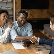 A couple shaking hands with a banker.