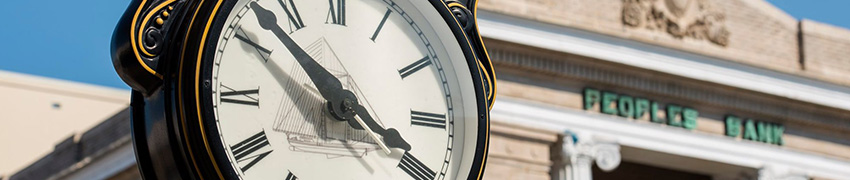 A clock outside of The Peoples Bank.