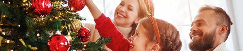 A family putting decorations on a Christmas tree