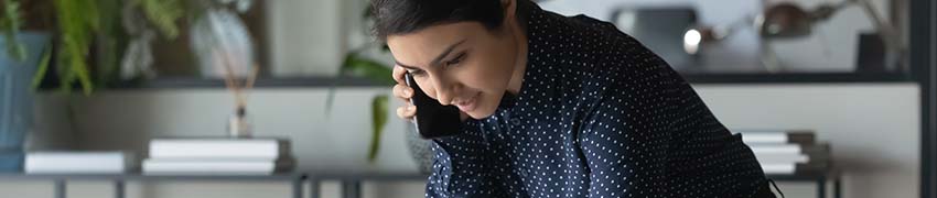 A woman going over her finances while on the phone