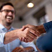 A smiling man shaking hands with a banker.