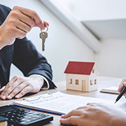 A realtor handing the keys to a new home to a client.