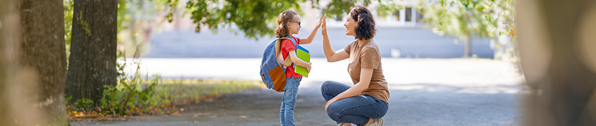 A girl gives her mom a high-five at school.