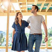 A happy couple walking through their new home under construction.