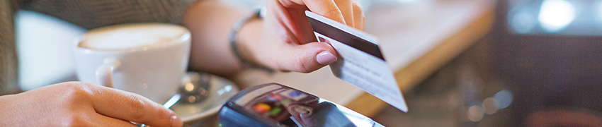 A pair of hands using a debit card.