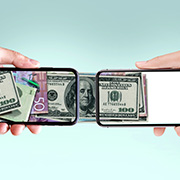 Dollar bills transferring between two phones.